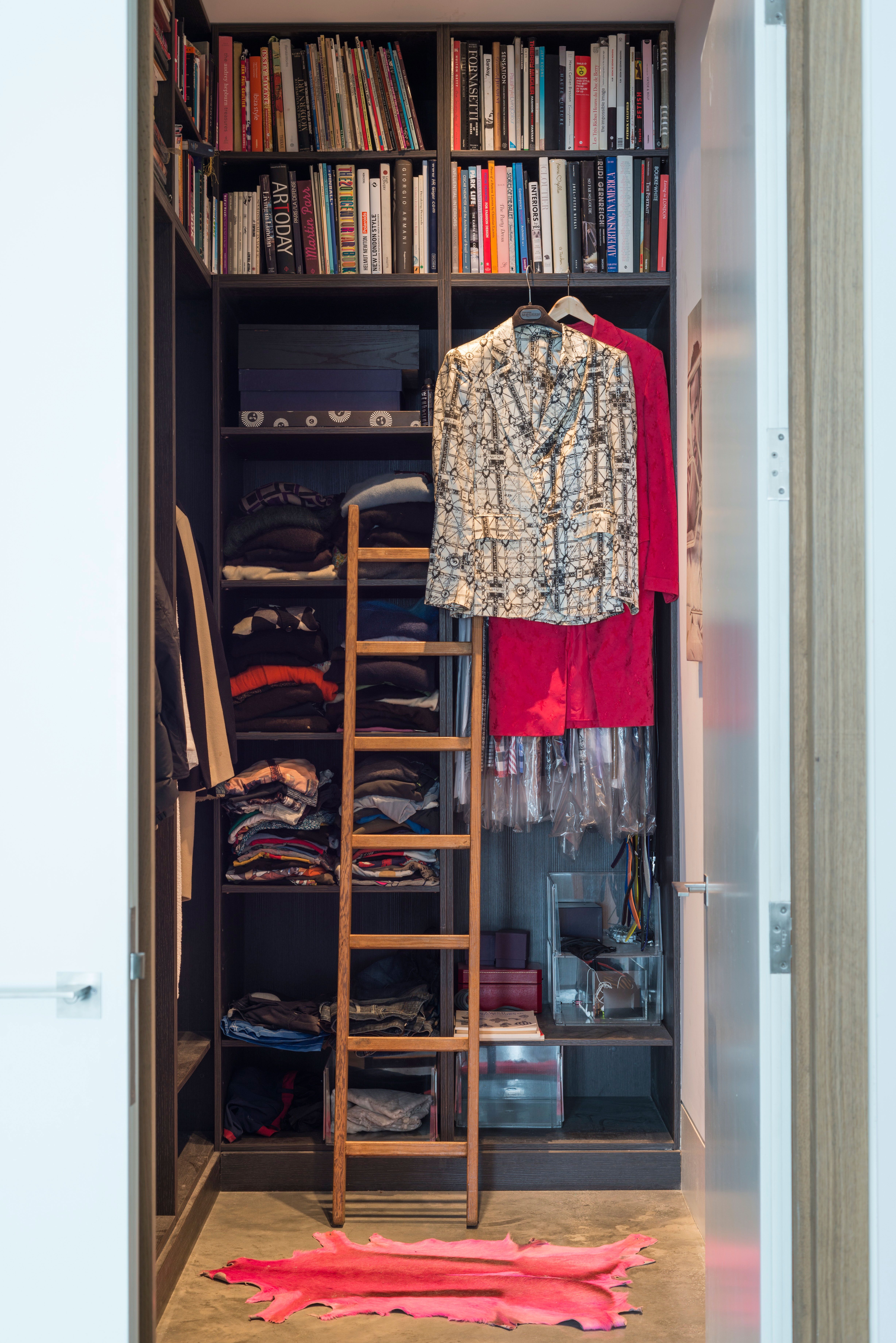 Black walk in closet with folded clothes