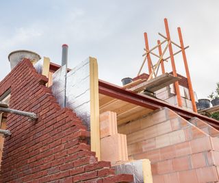 image of house being constructed showing side elevation of brick and insulation