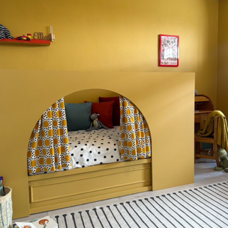 finished Kura bed hack in kids room. It's pinted mustard and has matching orange accessories.