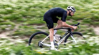 A white and black pinarello F9 against a background of foliage