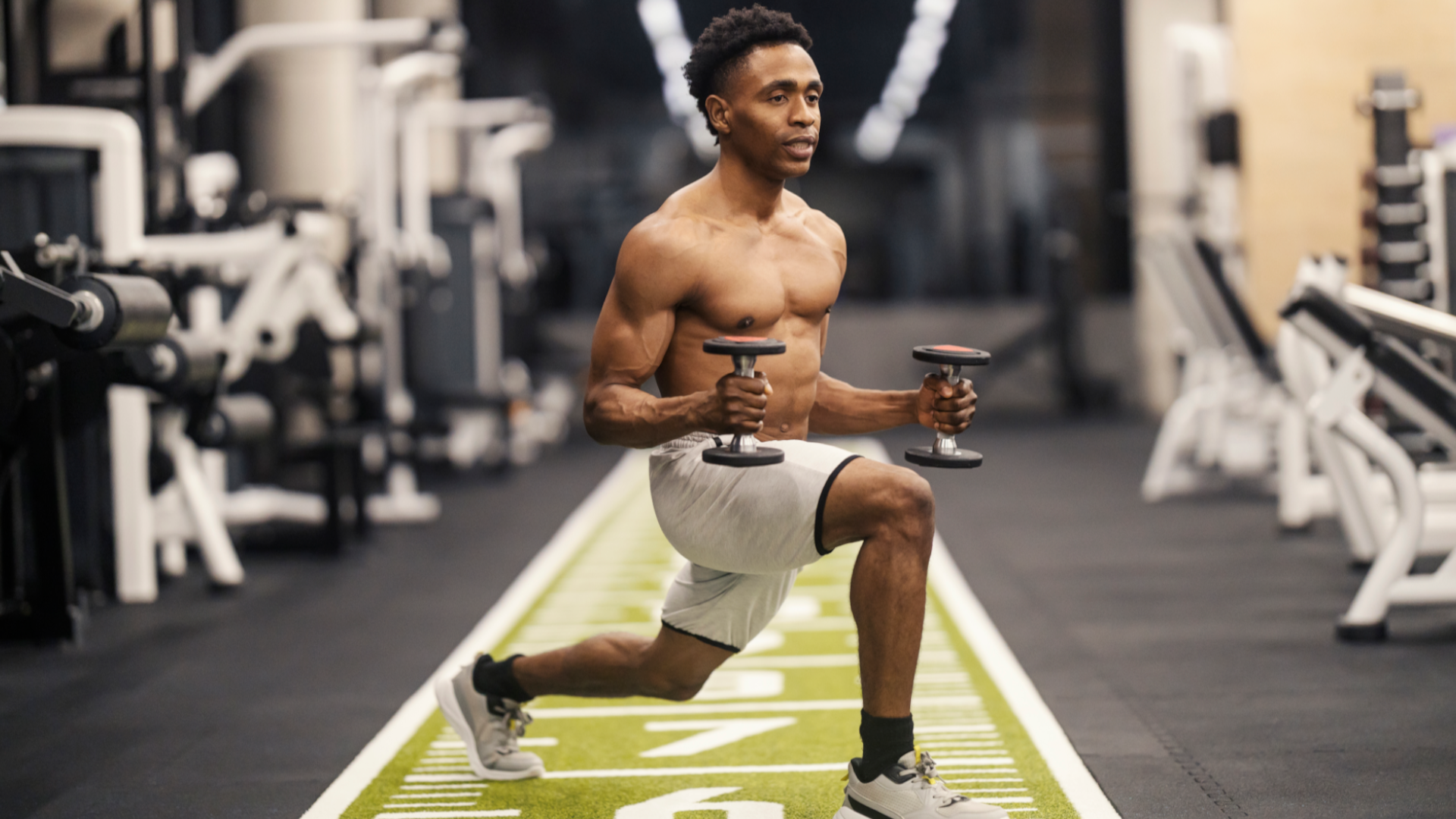 A man doing a lunge with two light dumbbells