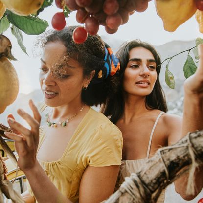 two women looking at fruit tree in summer clothes