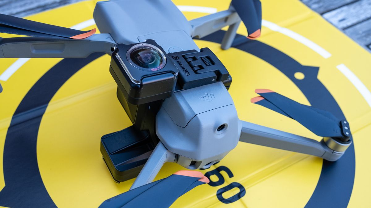 A DJI drone on a wooden table connected to the Insta360 Sphere 360 camera