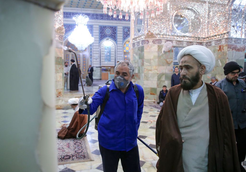 A sanitary worker disinfects the Masumeh shrine