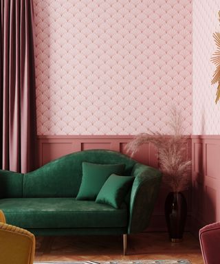 A room with pink wallpaper and dark pink paneling and curtains, a dark green chaise lounge, and a patterned rug