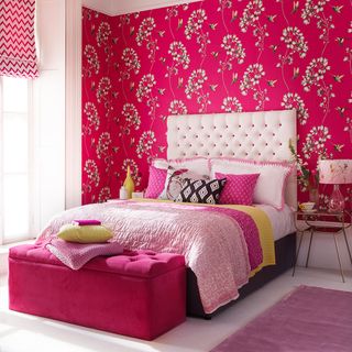 pink designed wall bedroom with pink bed and colourful cushion and white flooring