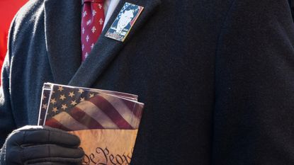 Donald Trump supporter carries copies of the U.S. Constitution at his 2025 inauguration