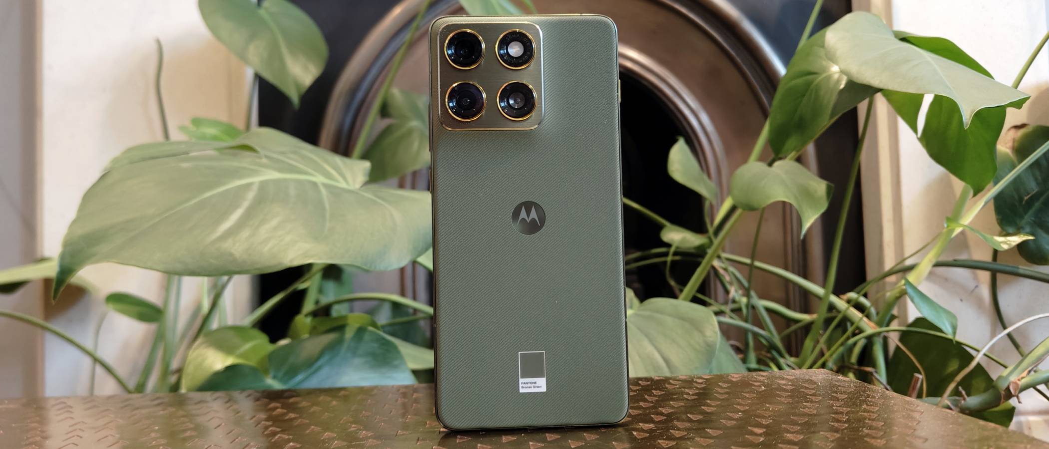 The Motorola Edge 70 perched on a brown table.