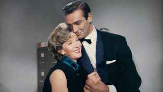 Lois Maxwell and Sean Connery share a hug at the office in Dr. No.