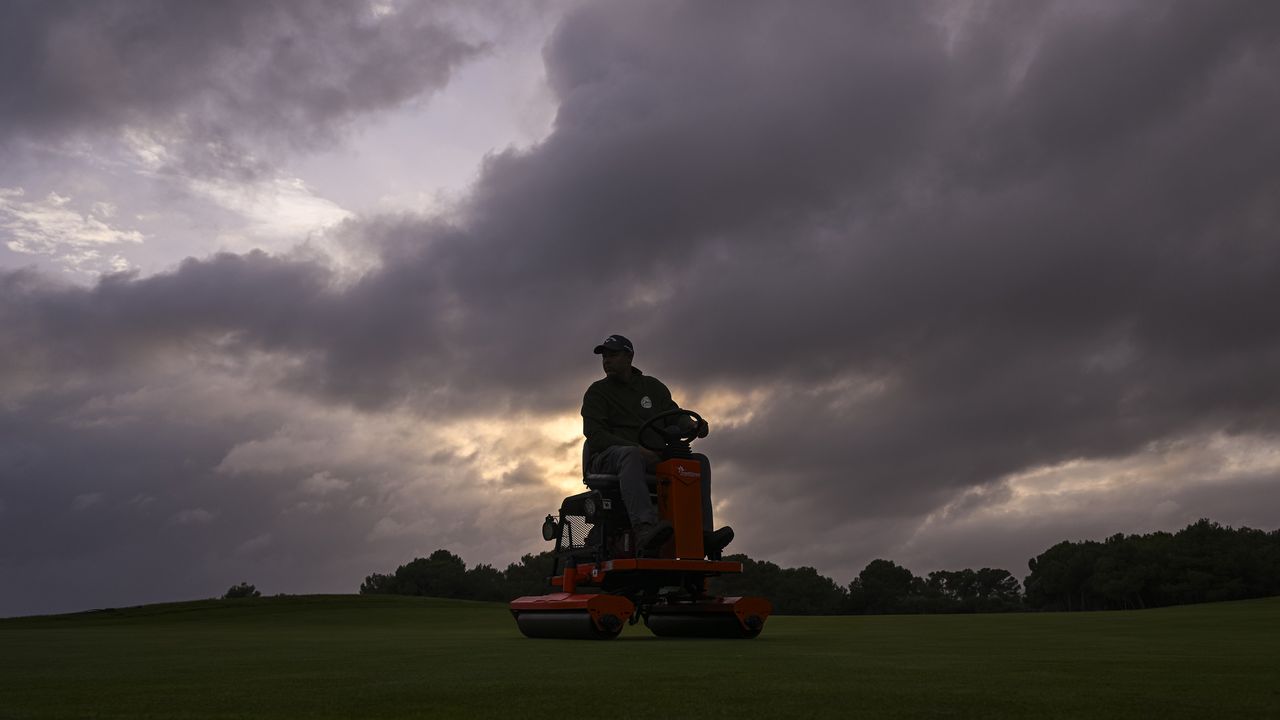 Greenkeeper mowing