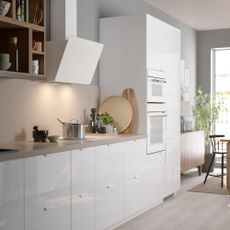 White kitchen storage units and countertop with induction hob