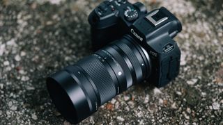 Sigma 50-120mm F2.8 DC OS Contemporary lens attached to a Canon EOS R7, rested on a rock
