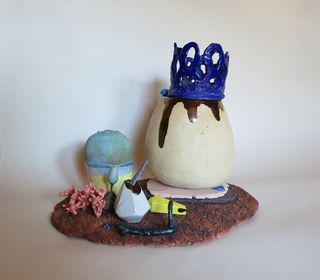 Art sculpture with an egg, crown and landscape