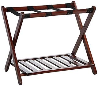 A brown wooden folding luggage rack with black fabric straps to hold a suitcase