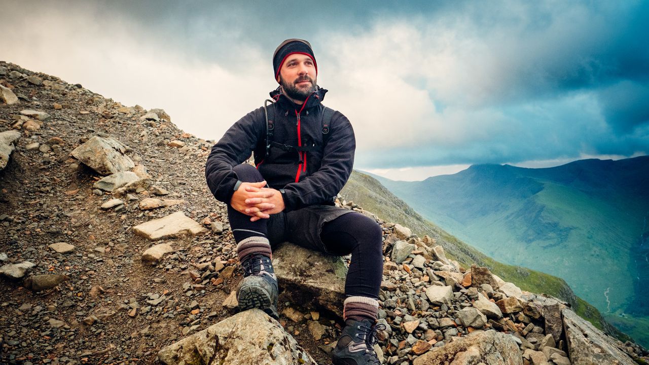 A man sat on a mountain during a hike