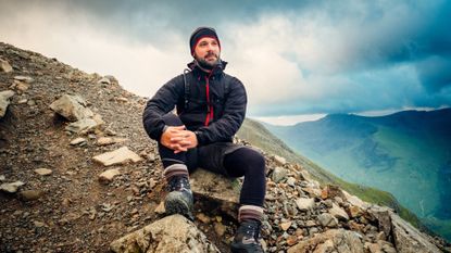 A man sat on a mountain during a hike