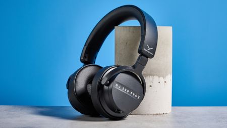 the beyerdynamic DJ 300 Pro X headphones in black showing their ear cups, carry bag, and connectivity options photographed against the blue tom's guide background