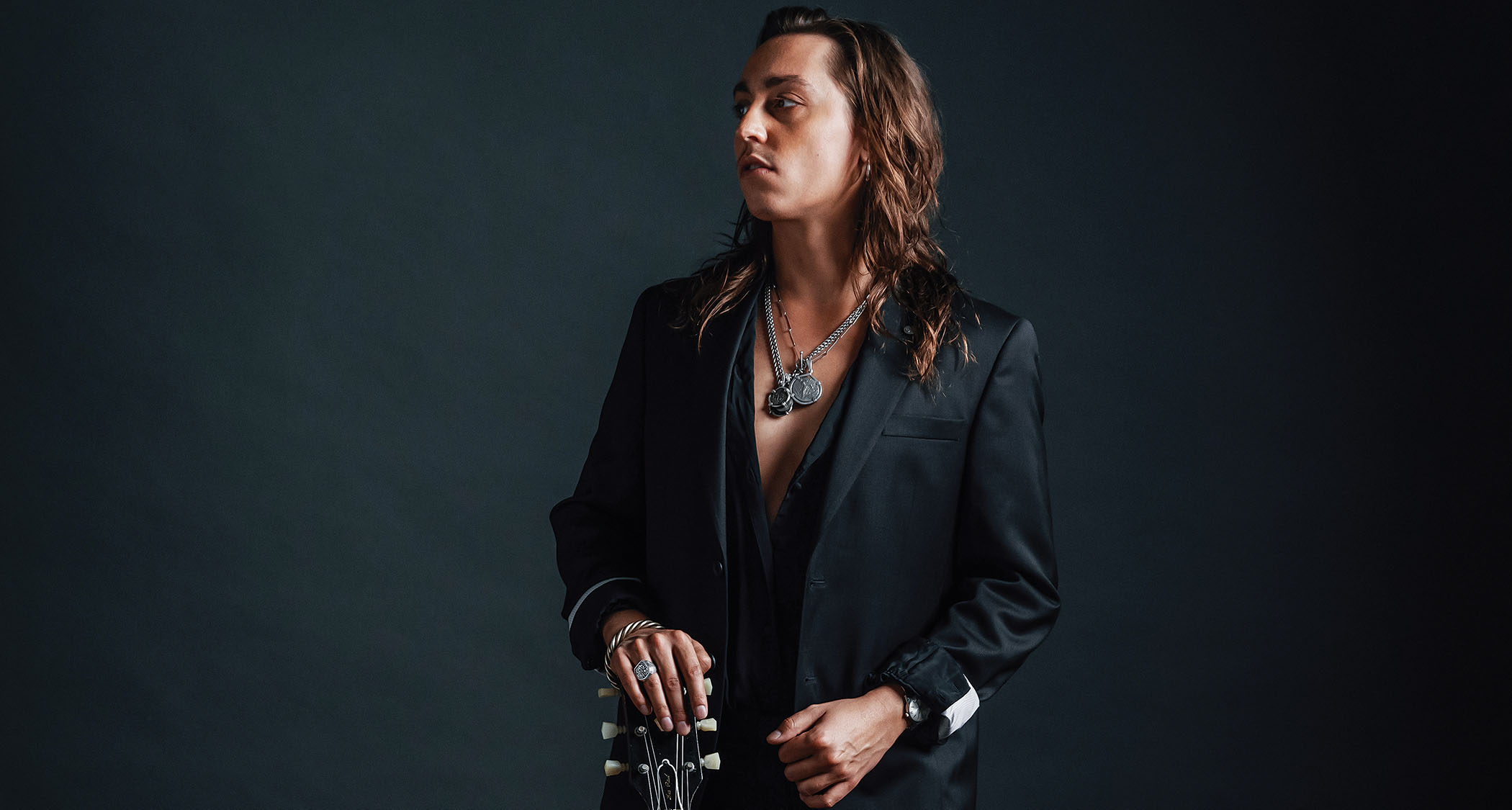 Jake Kiszka of Greta Van Fleet and Mirador wears a dark suit and is photographed with his trusty Gibson SG