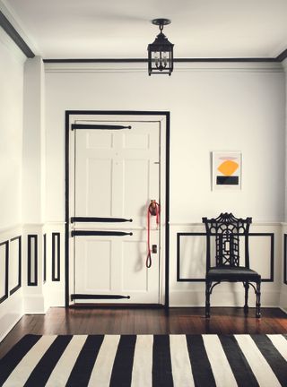 Black paint around crown molding makes for a bold doorway