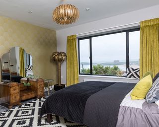 bedroom with yellow curtains and bronze palm tree