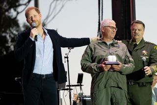 Prince Harry, Duke of Sussex (L) presents an award to Santa Barbara County Air Support Pilot Loren Courtney during the One805Live Fall Concert on September 20, 2024 in Carpinteria, California