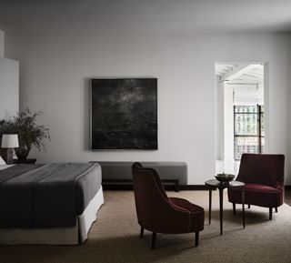 A grey bedroom with jewel tone chairs