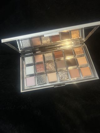 an open Huda Beauty Icy Nude Eyeshadow Palette against a black background