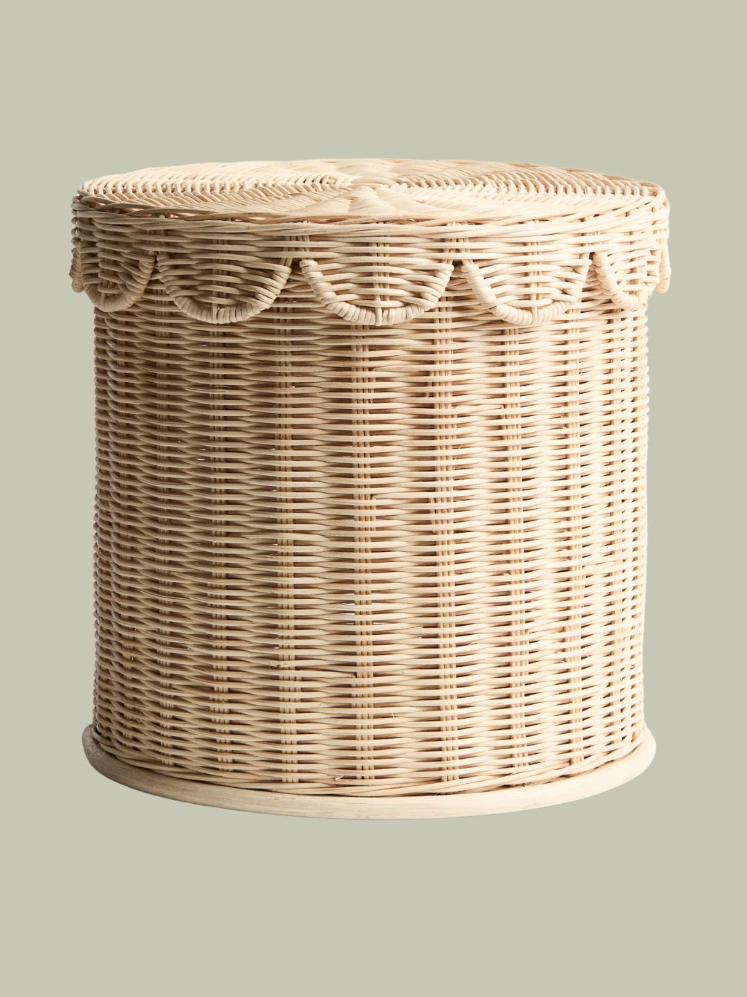 Handmade Rattan Storage Stool against pale green background.