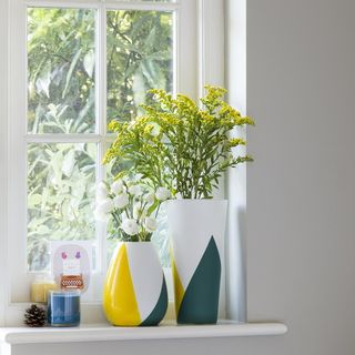 white window with flower vase and white wall