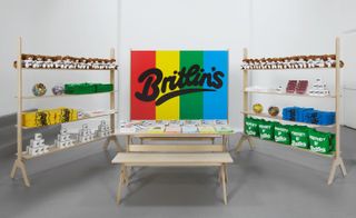 Multicoloured "Britlin's" sign, with shelving either side displaying teddies and folded t-shirts