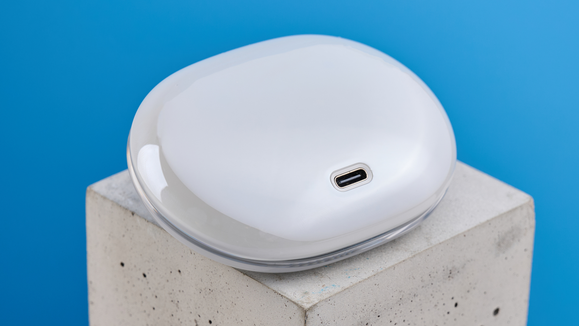 AceFast AceFit Pro open earbuds and the light up charging case photographed in front of a blue background.
