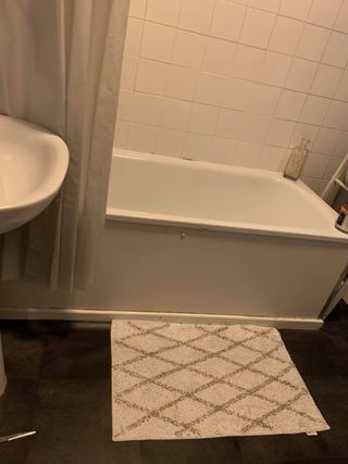 bathroom with white box tiles and bathtub