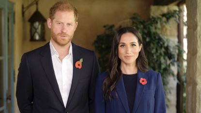 Prince harry and Meghan Markle wearing blue blazers and red poppy pins