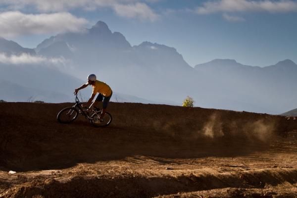 Beautiful mountains in the background as a rider rails around a berm.