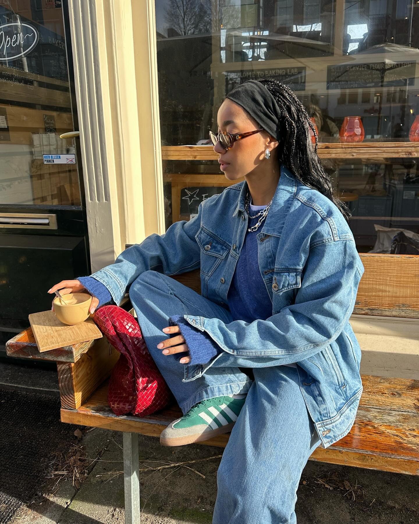 @amaka.hamelijnck wearing a denim jacket and jeans with green Adidas sneakers.