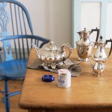 wooden table with blue chair and silver teapot