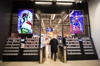 Digital signage from PPDS displaying the Grinch and 'Christmas Vacation' at a grocery store.