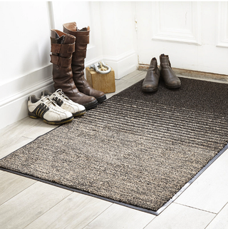 black ombre door mat in a white hallway with wooden floor