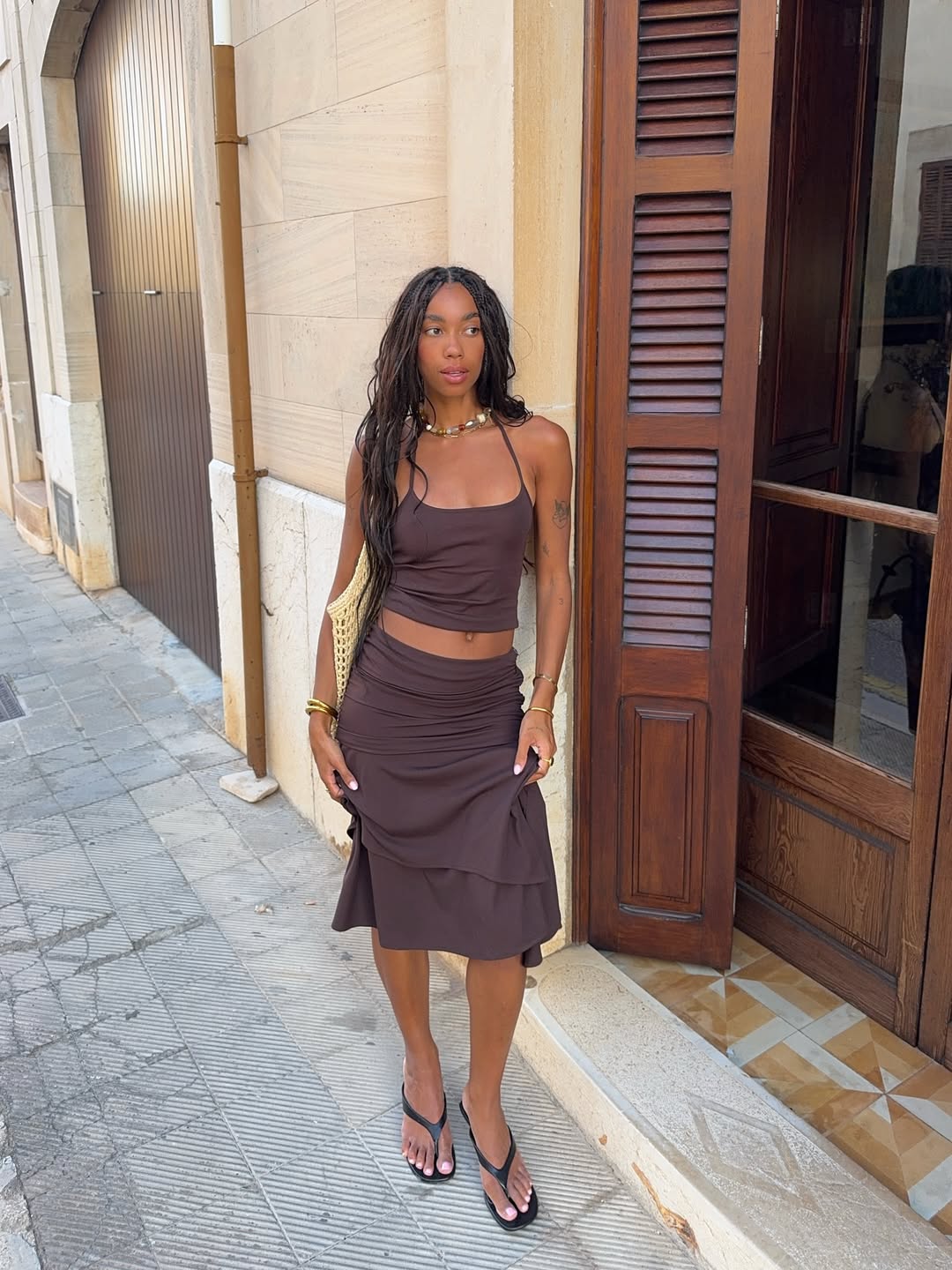 Amaka Hamelijnck wears a neutral set with waist-length goddess braids while vacationing in Palma De Mallorca, Spain