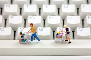 Shoppers with trollies on computer keyboard