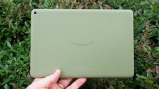 Amazon Fire HD 10 2021 held in one hand, showing the green-colored back