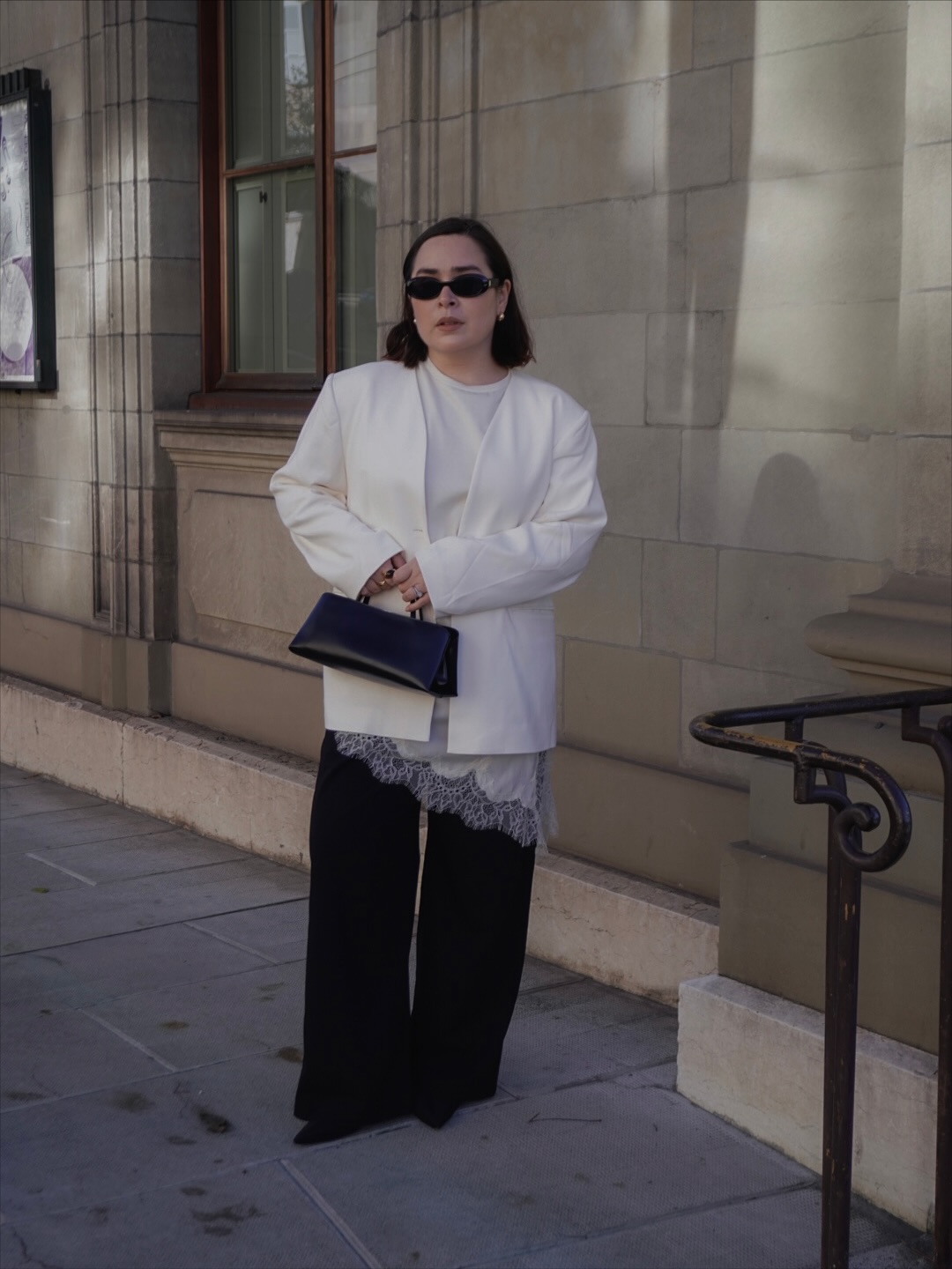 Influencer Indira C wearing a white blazer and cami with black trousers.