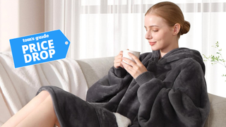 Woman lounging in a grey Touchat Hoodie Blanket