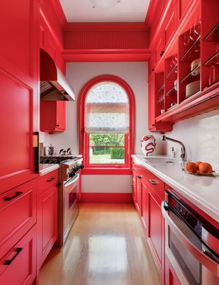 Galley kitchen with red painted cabinets
