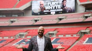 Tyson Fury at Wembley Stadium standing in front of a poster for his fight with Dillian Whyte