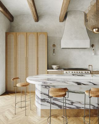 A kitchen with a white marble, fluted island