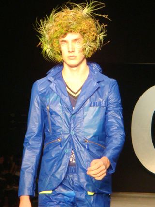 Male model with a jacket and trousers in bright blue, and bird's nest hair