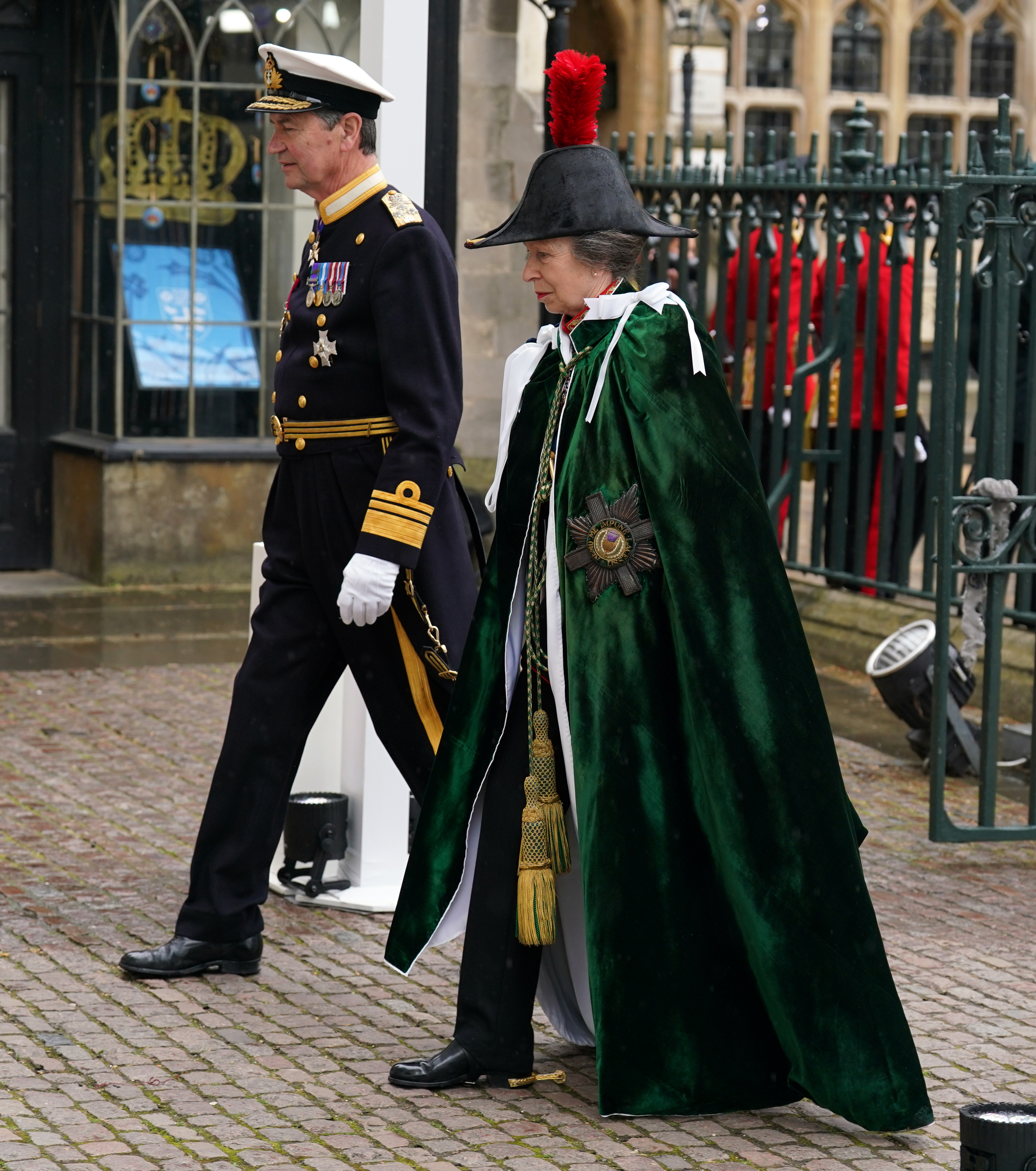 Princess Anne wearing a cape walking with Sir Tim Laurence at the coronation