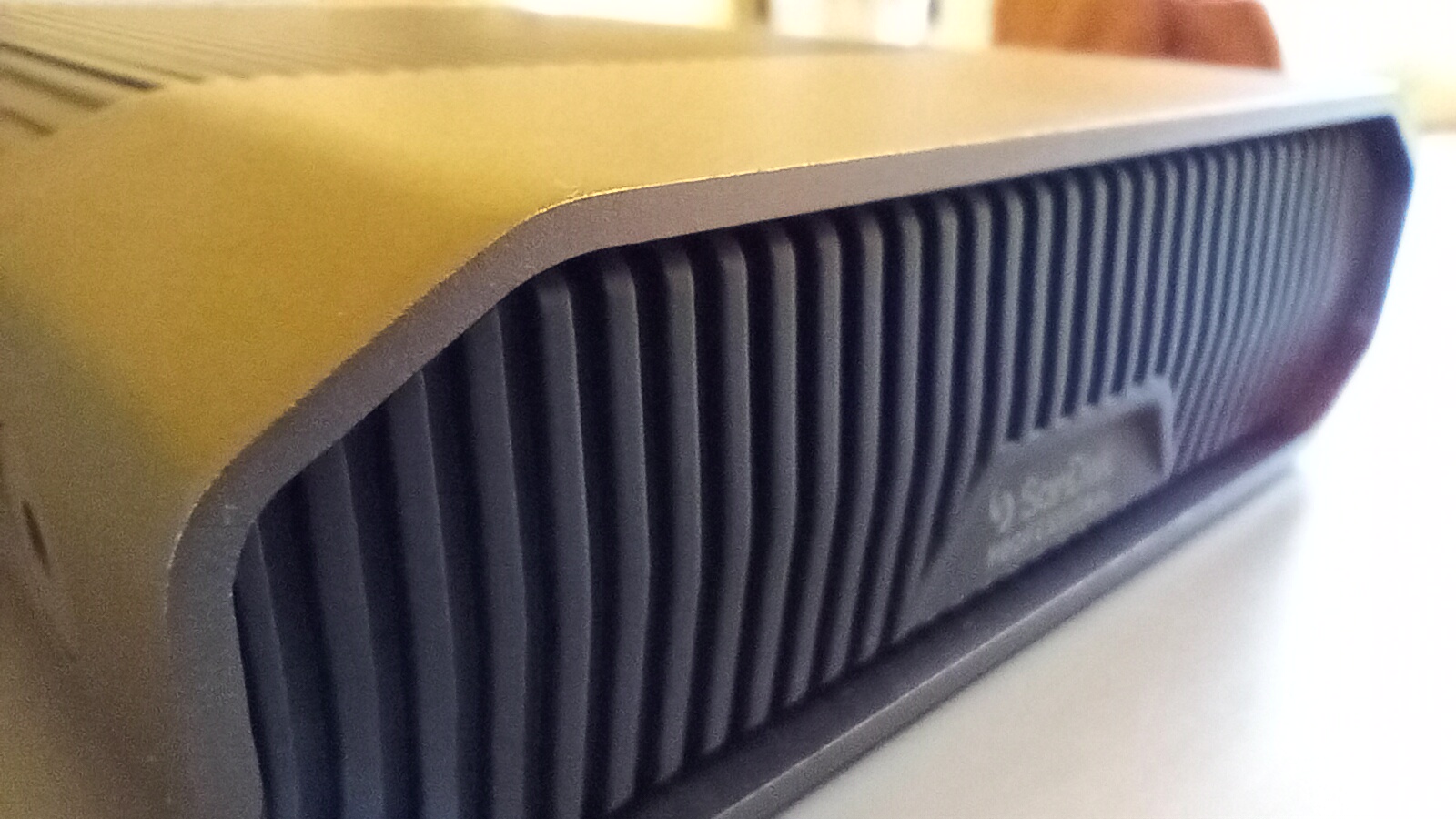 A grey aluminium SanDisk Professional G-Drive HDD on a table