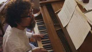 Peter Dinklage as Composer Steven Lauddem playing the piano in She Came to Me